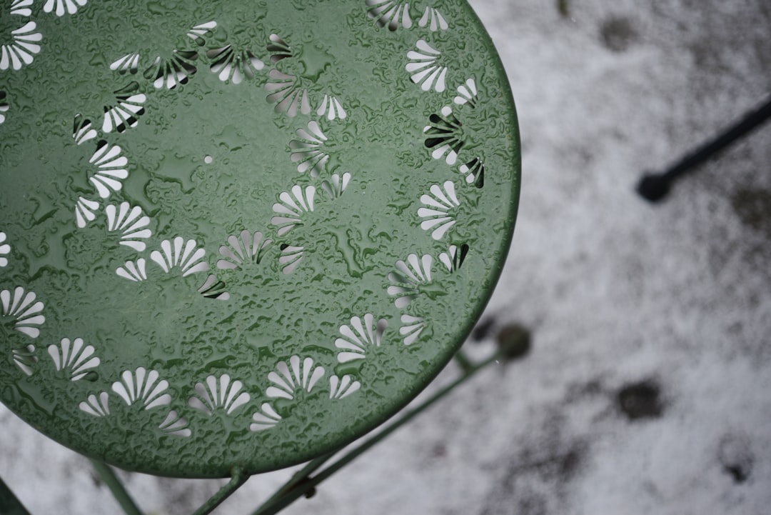 Green metal table with water droplets and snow.