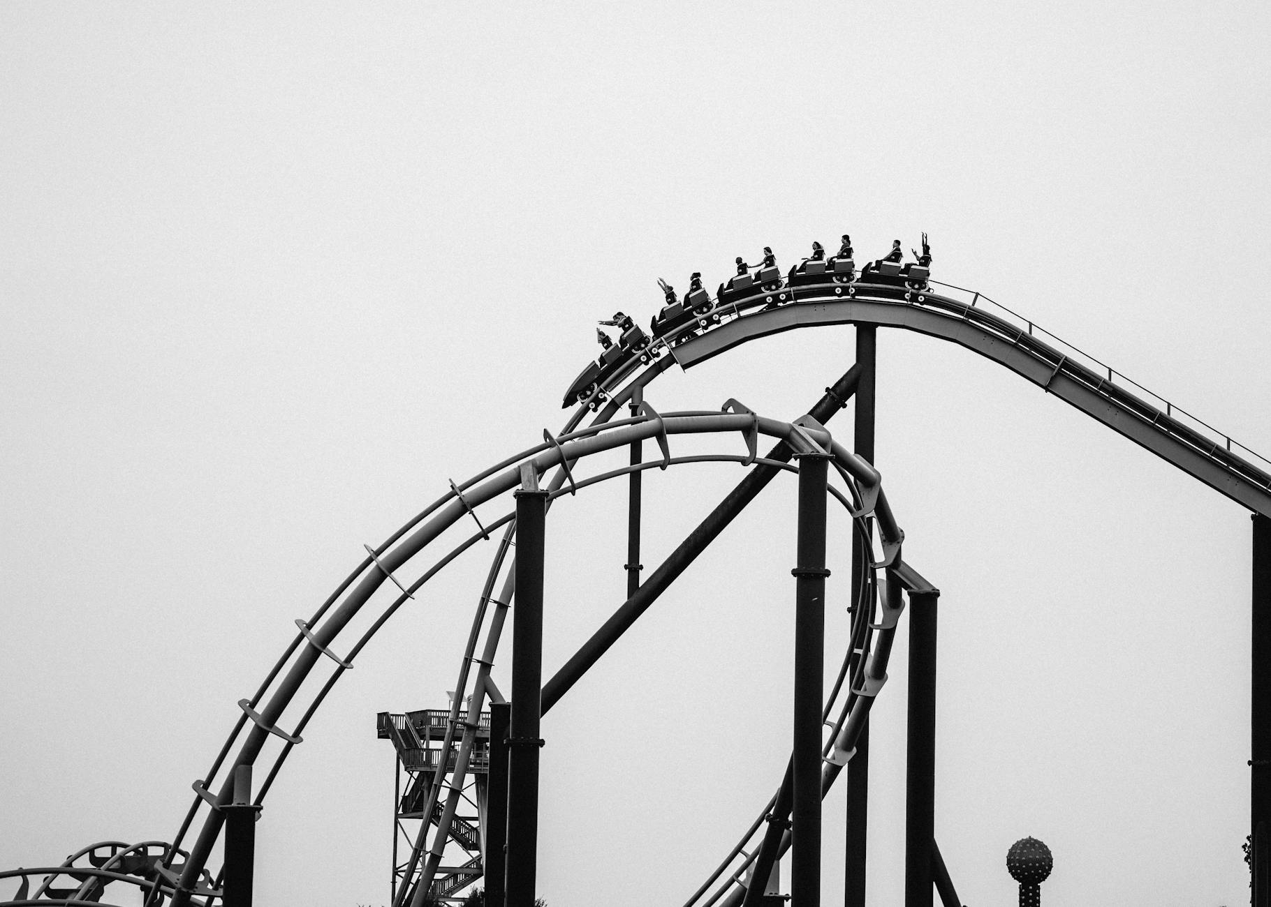 Black and white image of a thrilling roller coaster ride, capturing excitement and adventure.