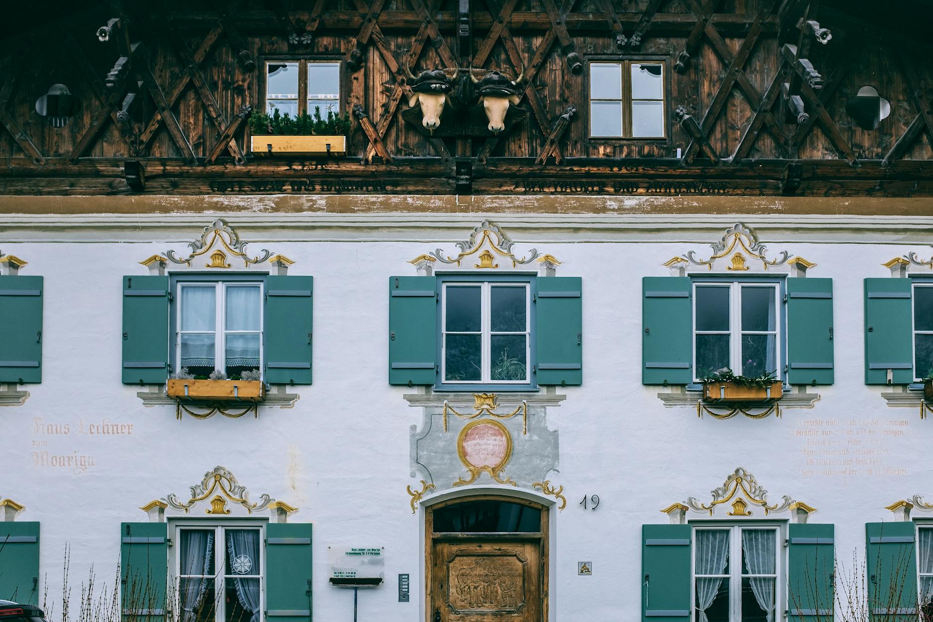 Textured background of aged building with decor and open window shutters in town in daylight